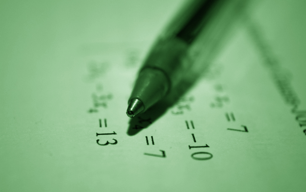 Pen with a paper full of solved math problems
